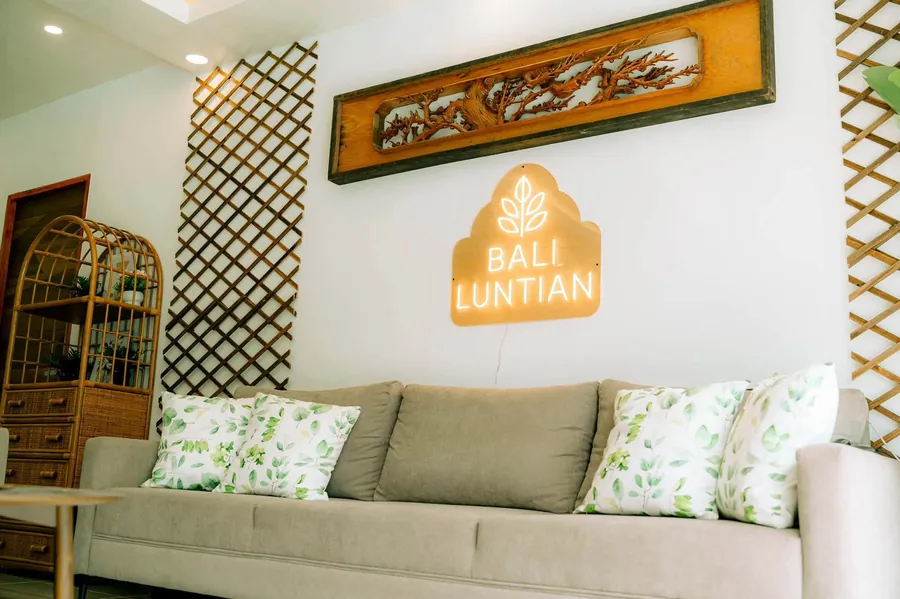 Sofa and cushions under the lit sign