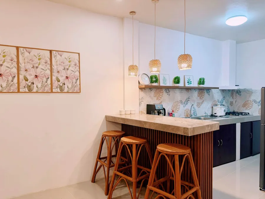 Kitchen breakfast bar with rattan stools and woven pendant lamps