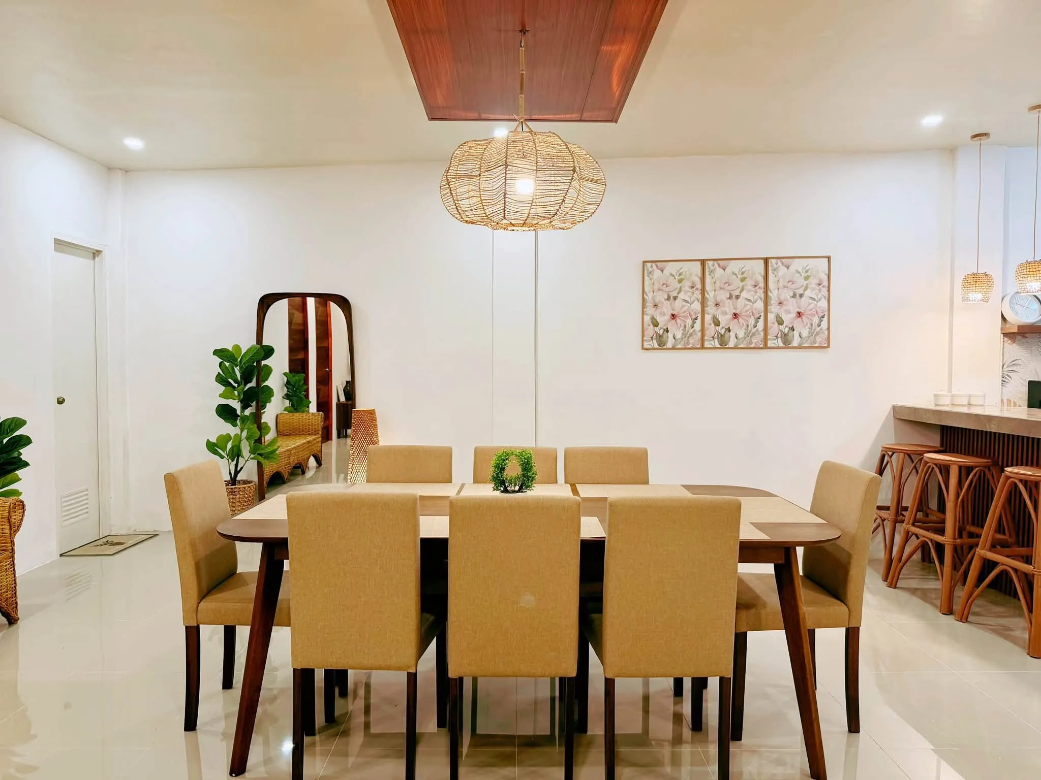 The indoor dining table set under a rattan pendant lamp