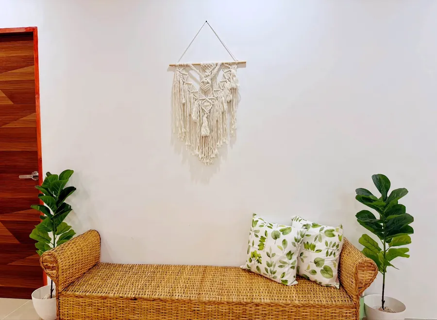 Rattan bench under a macrame wall hanging