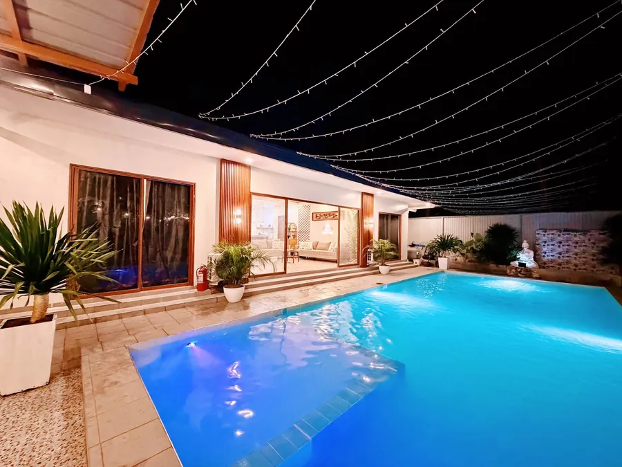 Wide view of the private pool beside the illuminated villa