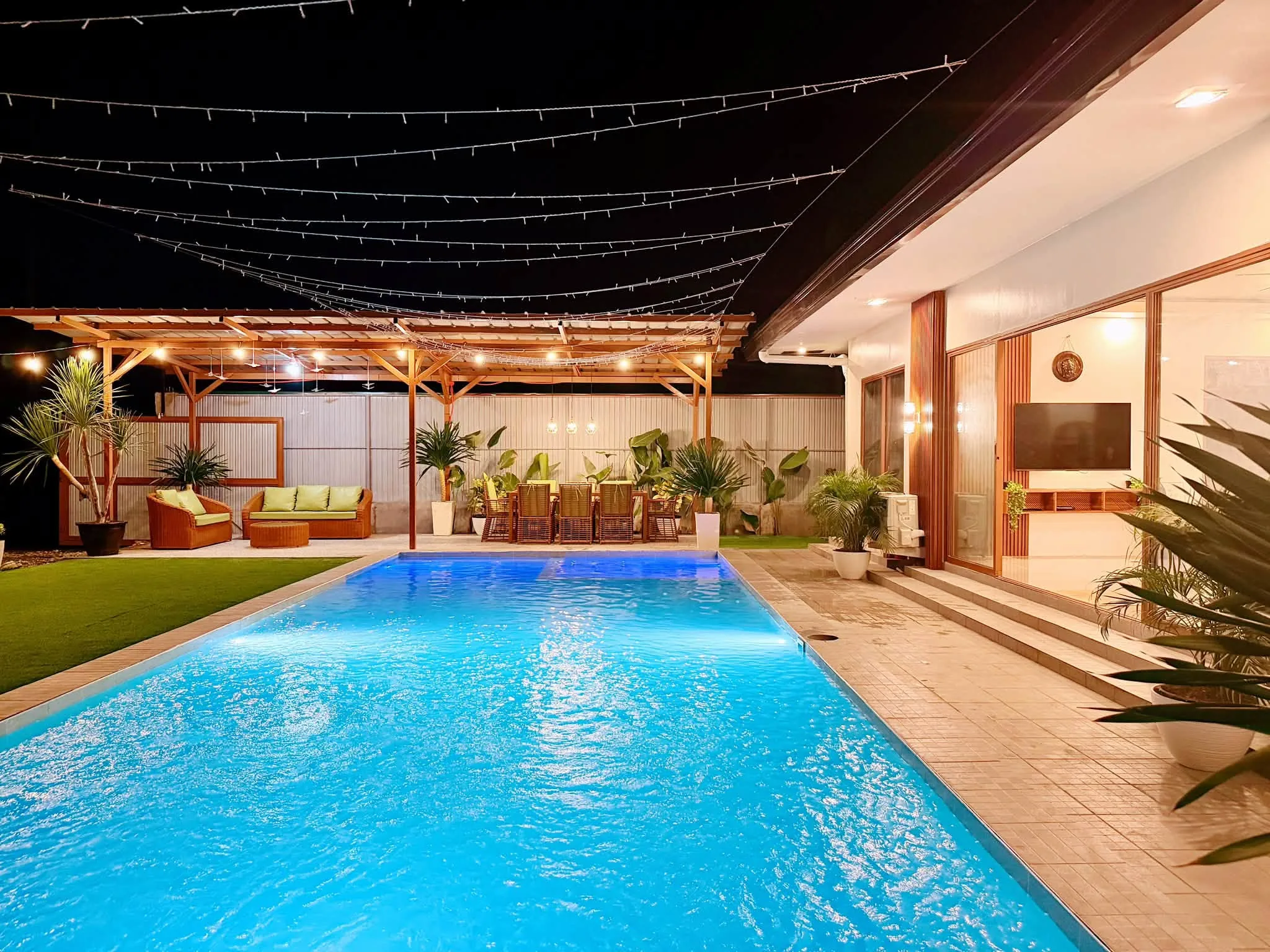 The pool and pergola lounge lit up at night