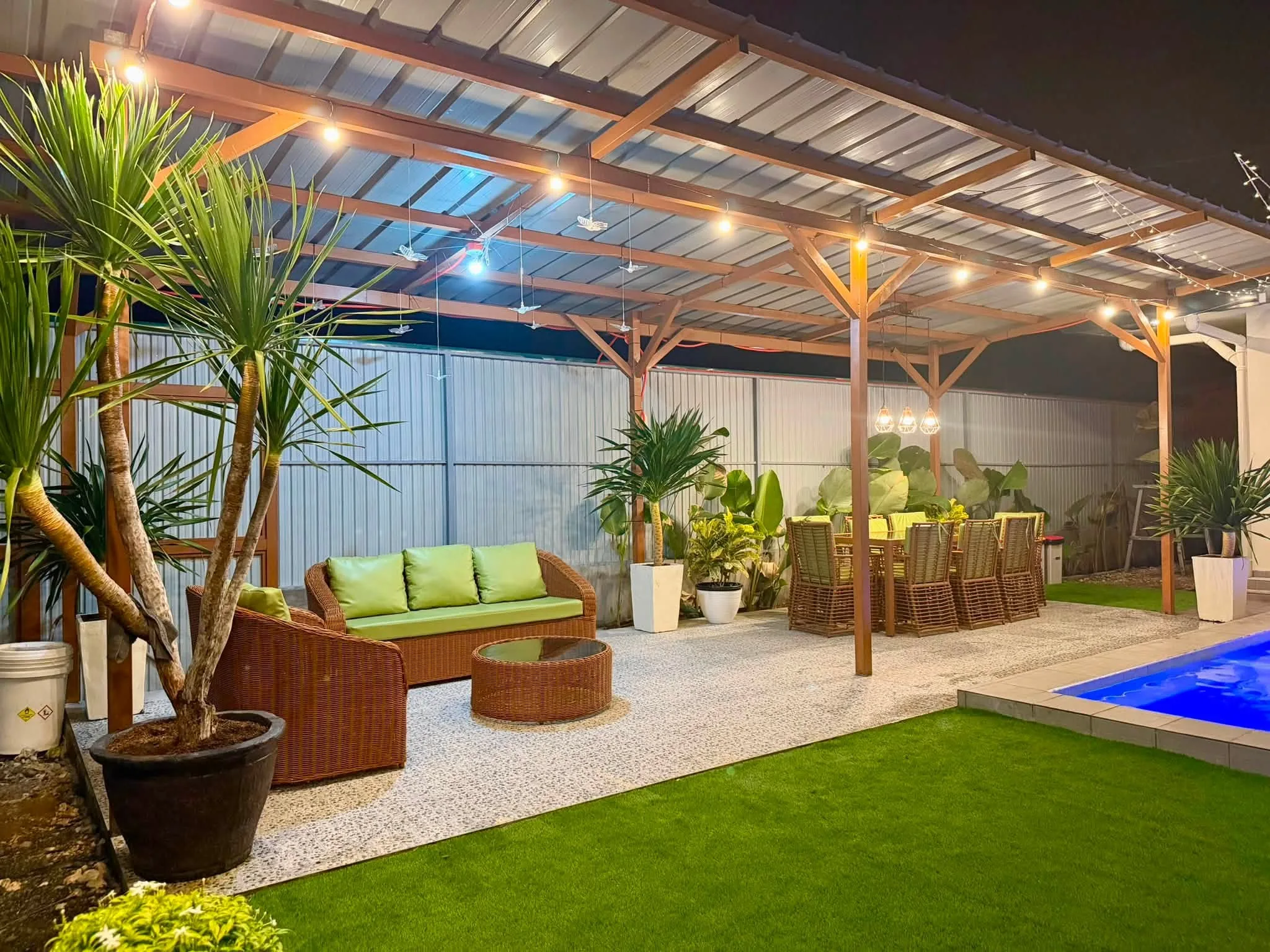 The pergola lounge with rattan sofas beside the long table
