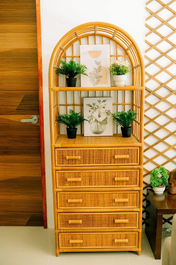 Rattan cabinet with plants and prints