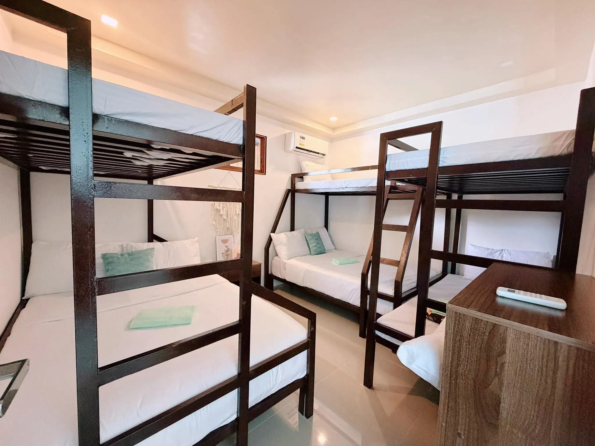 Air-conditioned bunk room with two double-deck beds and white linen