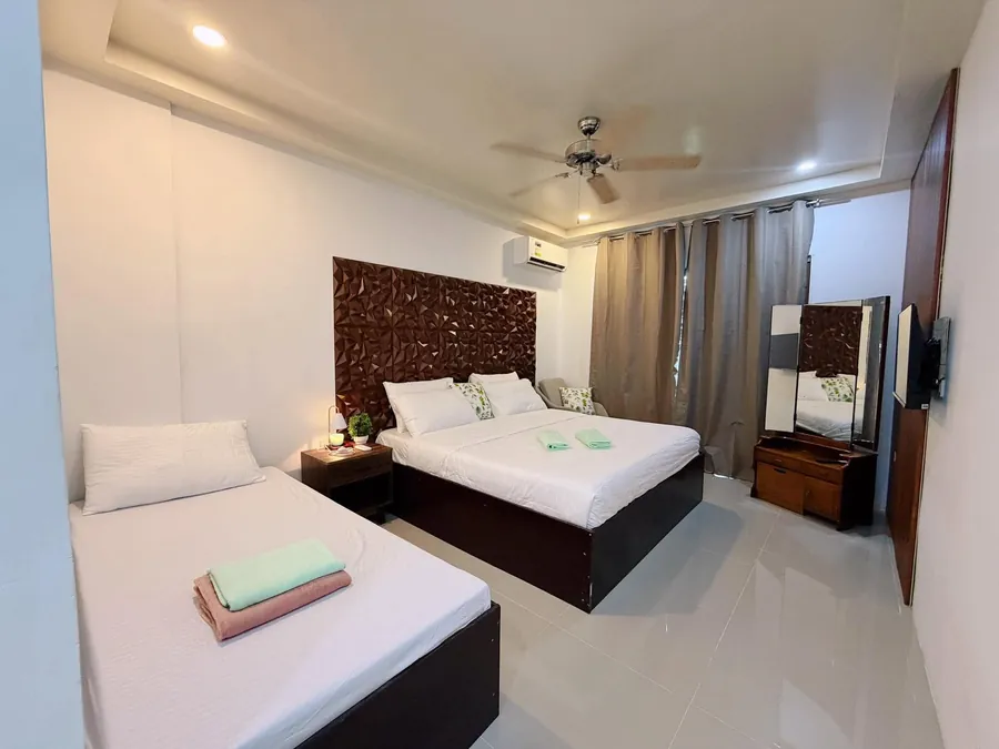 Master bedroom with a double bed, a day bed, ceiling fan and carved wood headboard
