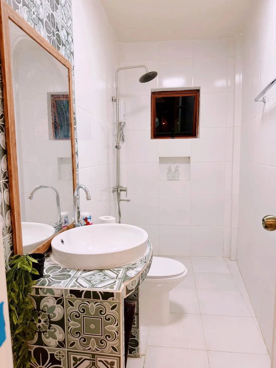 Bathroom with a patterned tile vanity, round basin and rain shower