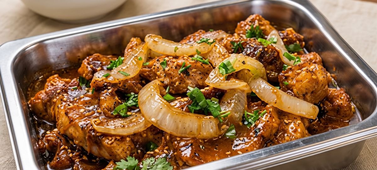 Pork steak with onions in a serving tray