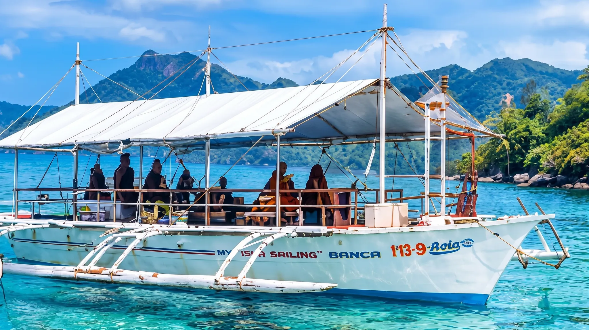 A private island-hopping boat on clear turquoise water near Samal